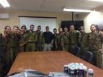 Group of IDF soldiers with civilian indoors behind conference table