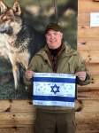 Man holding signed Israeli flag in front of Wolf painting