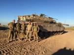 Five IDF soldiers in front of a tank