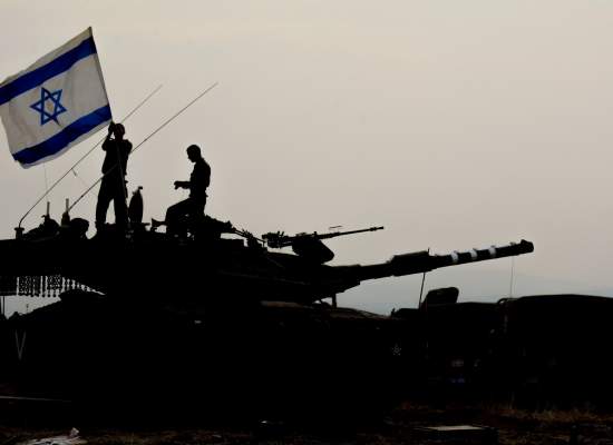 waving the Israeli flag standing on a tank