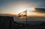 Israeli flag with the Sun shining behind it